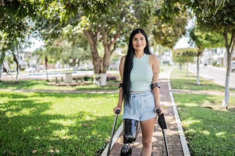 Young woman with prosthetic and crutches in park